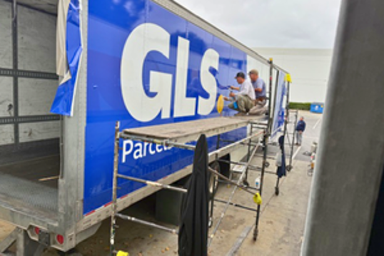 Installation of new GLS logos on a trailer